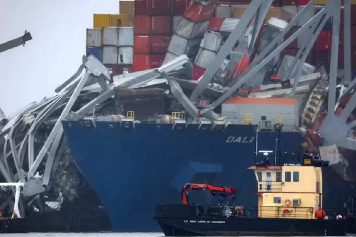  The crew consisting of Indian and Sri Lankan nationals aboard the container vessel Dali, which collided with the Francis Scott Key Bridge in Baltimore causing its collapse, will remain onboard until the investigation into the incident is completed. The vessel, with a crew of 20 Indians and one Sri Lankan, is currently engaged in regular duties while the investigation unfolds.  The cargo ship, measuring 984 feet, was en route to Colombo when it struck the bridge spanning the Patapsco river on March 26. Prior to the collision, there was a complete blackout on the ship, indicating a loss of engine and electrical power.  A spokesperson for Grace Ocean Pte and Synergy Marine, the owners and managers of the vessel respectively, confirmed the presence of 21 crew members onboard. These crew members are assisting both the National Transportation Safety Board and Coast Guard investigators alongside performing their regular duties on the ship.  The duration of the investigation remains uncertain, and until its conclusion, the crew will continue to stay aboard the vessel. Reports from the Baltimore International Seafarers’ Center affirm the crew's well-being.  The Indian embassy in Washington has been coordinating closely with the crew and local authorities. US authorities initiated questioning of the Dali crew last week, gathering pertinent documents and evidence.  While one crew member sustained minor injuries and received treatment, tragically, six members of a construction crew working on bridge repairs are presumed dead. Divers have recovered two bodies from a submerged red pickup truck, with efforts ongoing to locate the remaining victims.  President Joe Biden acknowledged the alert raised by the Dali crew about losing control, which enabled transportation authorities to close the Baltimore bridge prior to the collision, a move he emphasized undoubtedly saved lives.